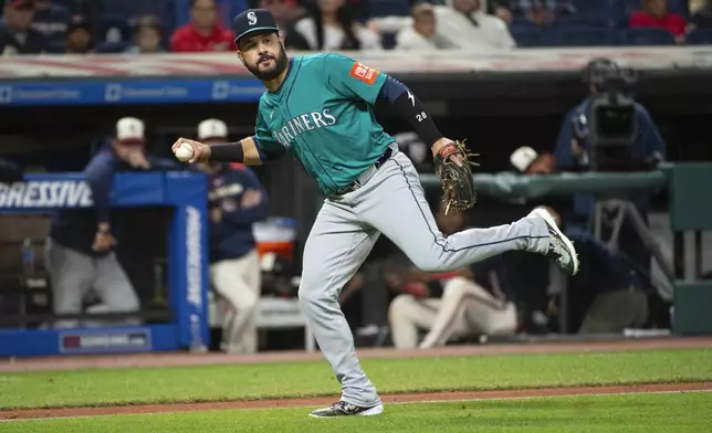Seattle Mariners' Eugenio Suarez gabs a bunt by Cleveland Guardians' Brayan Rocchio during the fifth inning of a baseball game, Friday, Aug. 29, 2025, in Cleveland. (AP Photo/Phil Long)