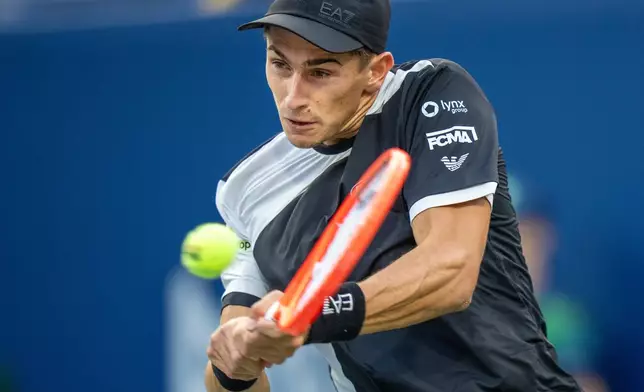 Matteo Arnaldi, of Italy, hits a backhand return to Alexander Zverev, of Germany, during their men's match at the National Bank Open tennis tournament in Toronto, Thursday, July 31, 2025. (Frank Gunn/The Canadian Press via AP)