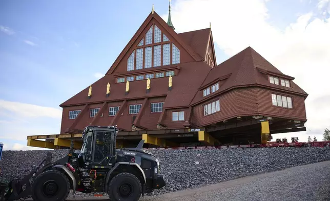 Construction machinery is parked next to the Kiruna Church, a Sami style wooden Swedish Lutheran church, called Kiruna Kyrka in Swedish, in Kiruna, Sweden, Wednesday, Aug. 20, 2025, after the completion of its move along a 5-km. (3-mile) route east to a new city center as part of the town's relocation.(AP Photo/Malin Haarala)