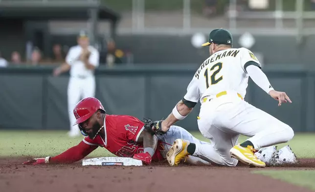 Athletics third baseman Max Schuemann, right, attempts to tag out Los Angeles Angels' Luis Rengifo as he steals second base during the second inning of a baseball game Saturday, Aug. 16, 2025, in West Sacramento, Calif. (AP Photo/Sara Nevis)