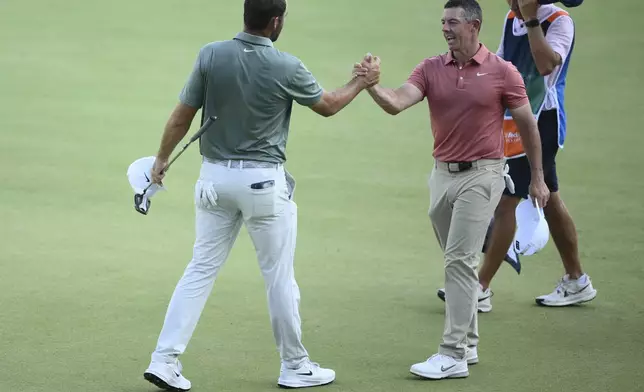 Rory McIlroy, right, of Northern Ireland, shakes hands with Scottie Scheffler, left, after they finished their second round of the BMW Championship golf tournament at Caves Valley Golf Club, Friday, Aug. 15, 2025, in Owings Mills, Md. (AP Photo/Nick Wass)