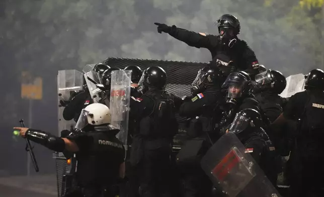Serbian gendarmerie officers patrol in truck during an anti-government protest near Serbian Progressive Party office in Belgrade, Serbia, Friday, Aug. 15, 2025. (AP Photo/Darko Vojinovic)
