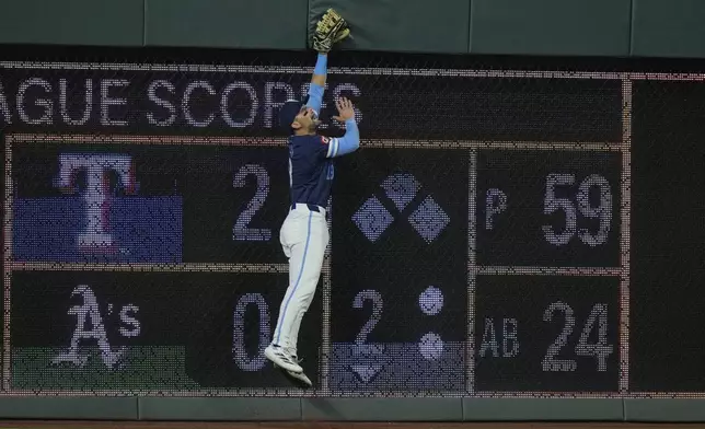 Kansas City Royals second baseman Michael Massey can't get to a solo home run hit by Detroit Tigers' Dillon Dingler during the eighth inning of a baseball game Friday, Aug. 29, 2025, in Kansas City, Mo. (AP Photo/Charlie Riedel)