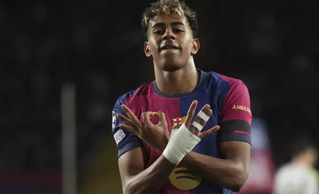 FILE - Barcelona's Lamine Yamal celebrates after scoring his side's second goal during the Champions League round of 16 second leg soccer match between FC Barcelona and SL Benfica at the Lluis Companys Olympic Stadium in Barcelona, Spain, Tuesday, March 11, 2025. (AP Photo/Emilio Morenatti, File)