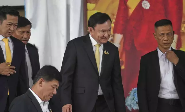 Former Thai Prime Minister Thaksin Shinawatra, center, leaves after a court acquitted Thaksin of royal defamation at Criminal Court in Bangkok, Thailand, Friday, Aug. 22, 2025. (AP Photo/Sakchai Lalit)