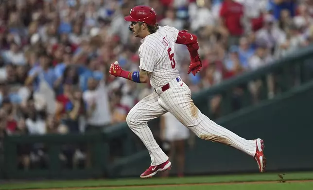 Philadelphia Phillies' Bryson Stott runs to third after hitting a one-run triple off of Baltimore Orioles pitcher Dean Kremer during the fourth inning of a baseball game, Tuesday, Aug. 5, 2025, in Philadelphia. (AP Photo/Matt Rourke)