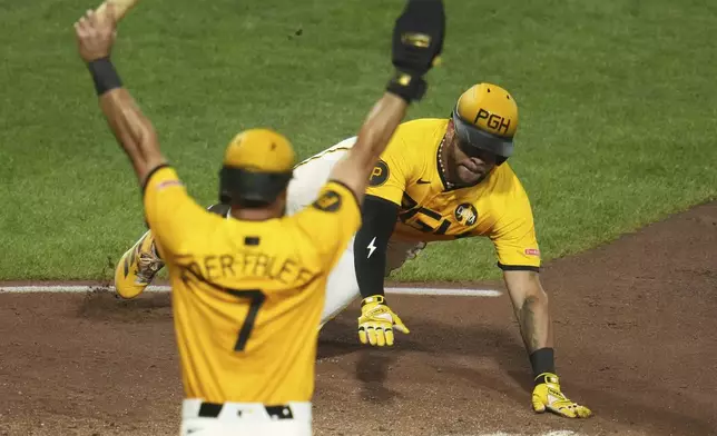 Pittsburgh Pirates' Tommy Pham, right, slides safely home with the second run driven in on a triple by Bryan Reynolds off Cincinnati Reds pitcher Tony Santillan during the eighth inning of a baseball game in Pittsburgh, Friday, Aug. 8, 2025. (AP Photo/Gene J. Puskar)