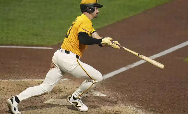 Pittsburgh Pirates' Bryan Reynolds follows through on a triple off Cincinnati Reds pitcher Tony Santillan, driving in two runs, during the eighth inning of a baseball game in Pittsburgh, Friday, Aug. 8, 2025. (AP Photo/Gene J. Puskar)