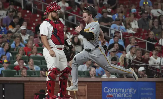 Pittsburgh Pirates' Jack Suwinski, right, scores past St. Louis Cardinals catcher Pedro Pages during the seventh inning of a baseball game Monday, Aug. 25, 2025, in St. Louis. (AP Photo/Jeff Roberson)