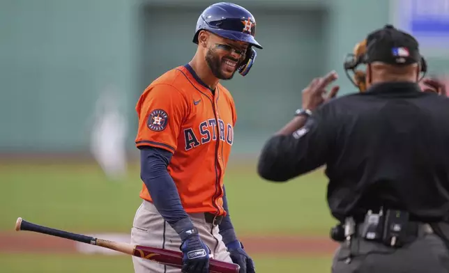 Houston Astros designated hitter Carlos Correa, left, jokes with umpire Laz Diaz, right, during the first inning of a baseball game against the Boston Red Sox at Fenway Park, Friday, Aug. 1, 2025, in Boston. (AP Photo/Charles Krupa)