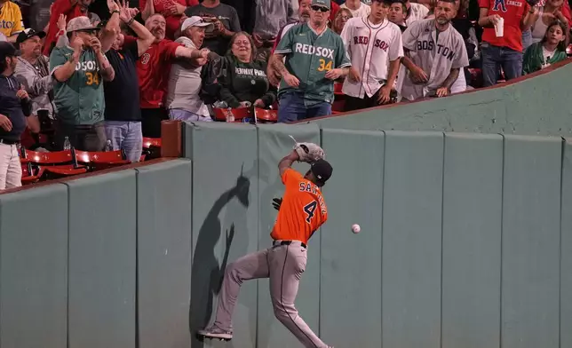 Houston Astros outfielder Jesus Sanchez (4) misses a catch on a foul ball hit by Boston Red Sox designated hitter Masataka Yoshida during the seventh inning of a baseball game at Fenway Park, Friday, Aug. 1, 2025, in Boston. (AP Photo/Charles Krupa)
