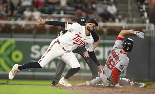 Minnesota Twins shortstop Carlos Correa, front left, tags out Boston Red Sox's Roman Anthony, right who was trying to steal second base during the ninth inning of a baseball game Monday, July 28, 2025, in Minneapolis. (AP Photo/Craig Lassig)