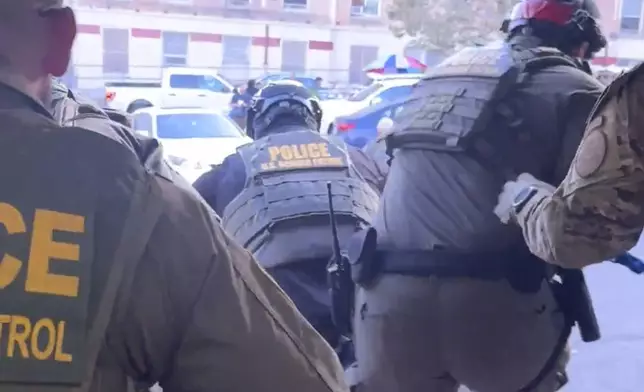 This image taken from video shows U.S. Border Patrol agents jumping out of a Penske box truck during an immigration raid at a Home Depot in Los Angeles, on Wednesday, Aug. 6, 2025. (FOX News/Matt Finn via AP)