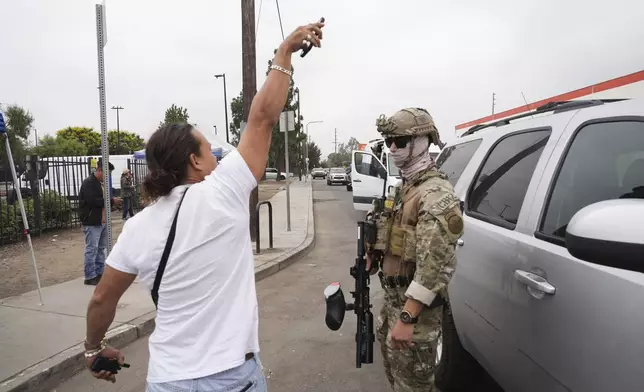 People film federal agents during an operation outside a Home Depot Friday, Aug. 15, 2025, in Los Angeles. (AP Photo/Gregory Bull)
