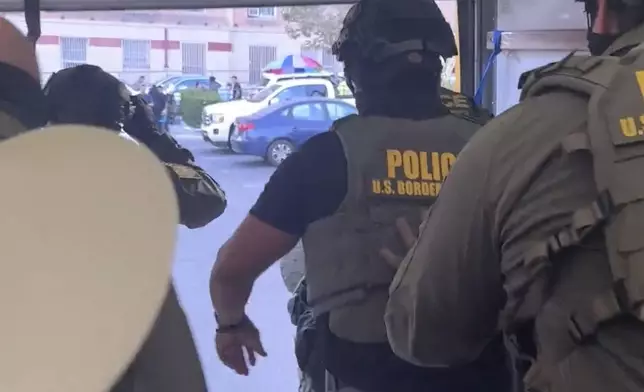 This image taken from video shows U.S. Border Patrol agents jumping out of a Penske box truck during an immigration raid at a Home Depot in Los Angeles, on Wednesday, Aug. 6, 2025. (FOX News/Matt Finn via AP)