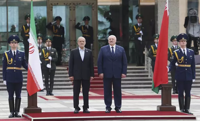 In this photo, released by Belarusian Presidential Press Service, Belarusian President Alexander Lukashenko, center right, and Iranian President Masoud Pezeshkian, center left, attend a welcome ceremony prior to their talks in Minsk, Belarus, Wednesday, Aug. 20, 2025. (Belarusian Presidential Press Service via AP)
