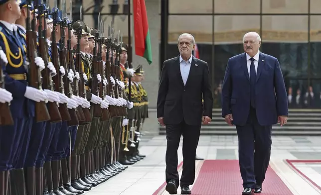 In this photo, released by Belarusian Presidential Press Service, Belarusian President Alexander Lukashenko, right, and Iranian President Masoud Pezeshkian attend a welcome ceremony prior to their talks in Minsk, Belarus, Wednesday, Aug. 20, 2025. (Belarusian Presidential Press Service via AP)