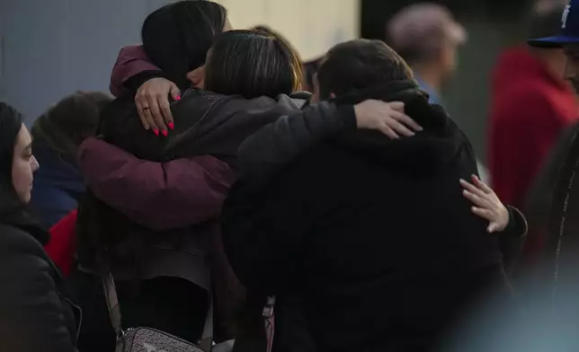 Relatives of a missing miner embrace in front of the offices of Codelco, operators of El Teniente copper mine where a cave-in killed one worker and trapped five others underground, halting operations in Rancagua, Chile, Saturday, Aug. 2, 2025. (AP Photo/Esteban Felix)