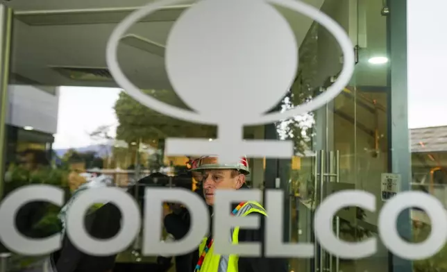 A worker stands inside an office of Codelco, the company that operates the El Teniente copper mine, where a cave-in killed one worker and trapped five others underground, halting operations in Rancagua, Chile, Saturday, Aug. 2, 2025. (AP Photo/Esteban Felix)