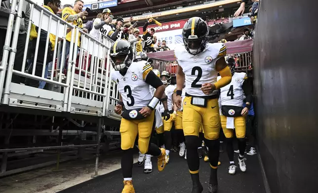 FILE - Pittsburgh Steelers quarterback Russell Wilson (3) and quarterback Justin Fields (2) lead there team onto the field before an NFL football game against the Washington Commanders, Sunday, Nov. 10, 2024, in Landover, Md. (AP Photo/Terrance Williams, file)