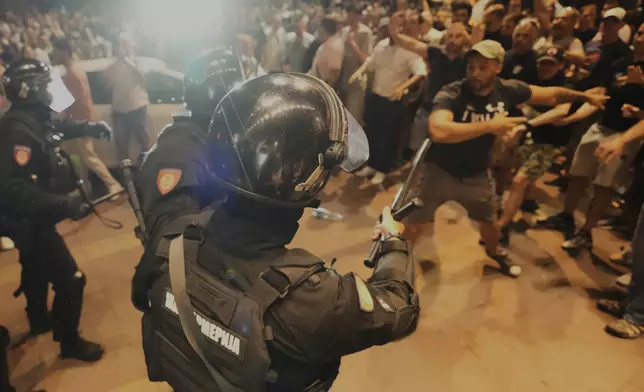 Serbian gendarmerie officers separate protesters from the opposing camps during an anti-government protest in Belgrade, Serbia, Wednesday, Aug. 13, 2025. (AP Photo/Darko Vojinovic)