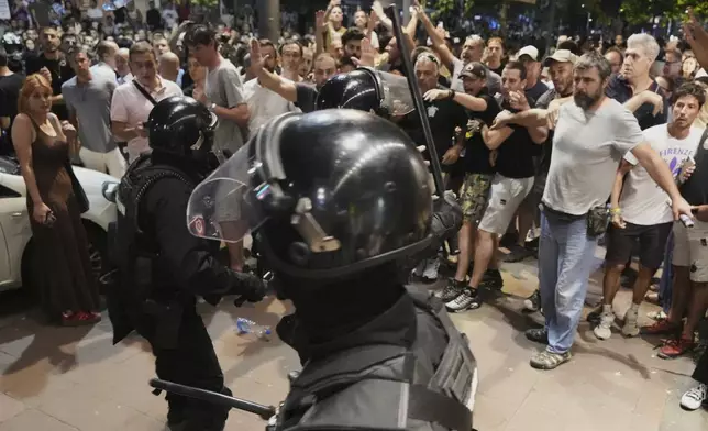 Serbian gendarmerie officers separate protesters from opposing camps during an anti-government protest in Belgrade, Serbia, Wednesday, Aug. 13, 2025. (AP Photo/Darko Vojinovic)