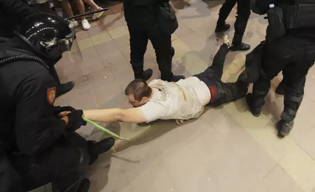 Serbian gendarmerie officers detain an alleged pro-government supporter during an anti-government protest in Belgrade, Serbia, Wednesday, Aug. 13, 2025. (AP Photo/Darko Vojinovic)