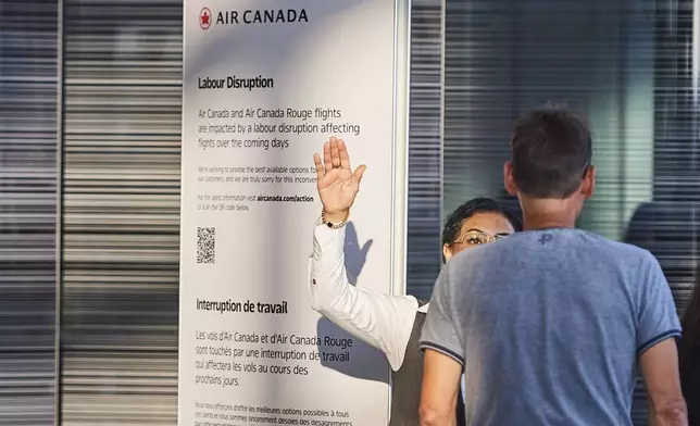 Travellers look for guidance at the Air Canada departure gates as flight attendants strike at Pearson International Airport in Toronto on Saturday, Aug. 16, 2025. (Sammy Kogan/The Canadian Press via AP)