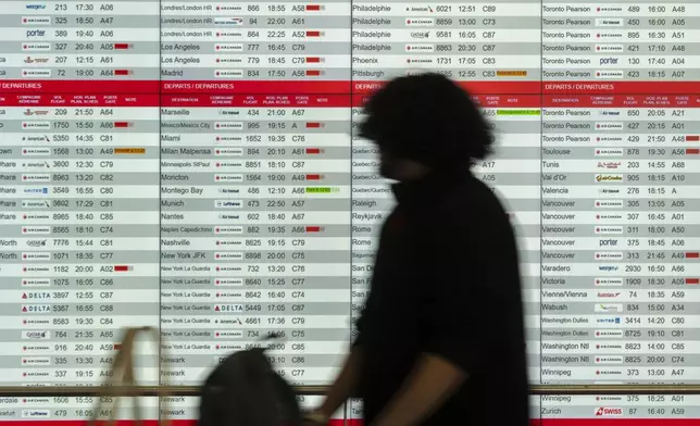 Cancelled and delayed Air Canada flights are seen on the departure board at Montreal-Pierre Elliott Trudeau International Airport in Dorval, Que., Friday, Aug. 15, 2025. (Christinne Muschi/The Canadian Press via AP)