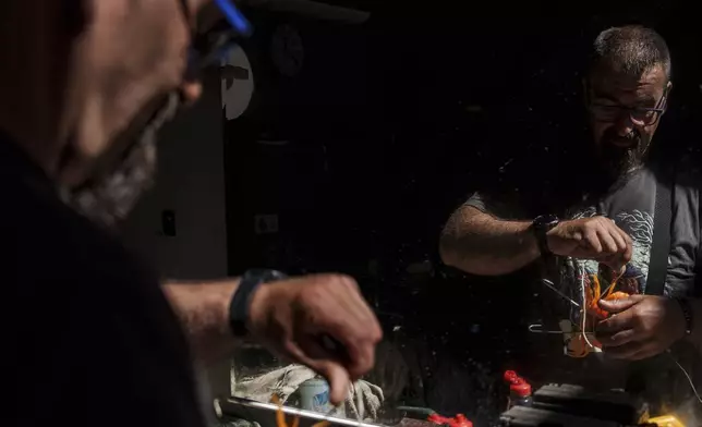 Octopus fisherman Juan Martinez demonstrates how to use the traditional octopus capture device his family has used for generations Thursday, June 26, 2025, in Cangas, Spain. (AP Photo/Annika Hammerschlag)
