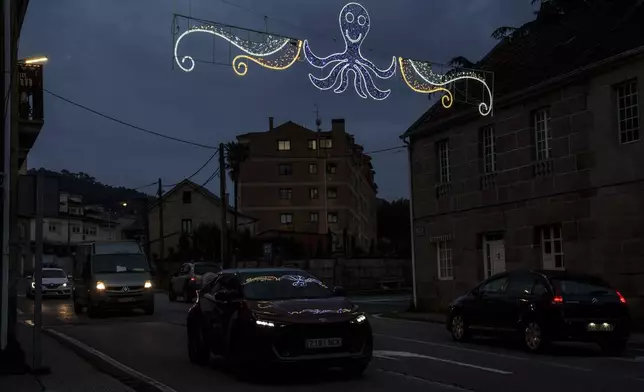Lights with likeness of an octopus is illuminated over a street Tuesday, June 24, 2025, in Pontevedra, Spain. (AP Photo/Annika Hammerschlag)