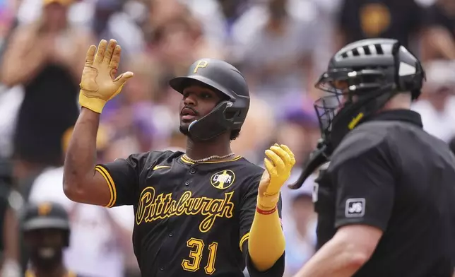 Pittsburgh Pirates' Liover Peguero is congratulated as he crosses home plate after hitting a three-run home run off Colorado Rockies starting pitcher Austin Gomber in the fifth inning of a baseball game Saturday, Aug. 2, 2025, in Denver. (AP Photo/David Zalubowski)