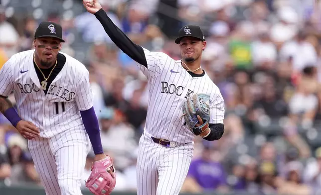 Colorado Rockies shortstop Ezequiel Tovar throws to first base to put out Pittsburgh Pirates' Nick Gonzales as third baseman Orlando Arcia, left, clears out of the way, in the third inning of a baseball game Saturday, Aug. 2, 2025, in Denver. (AP Photo/David Zalubowski)