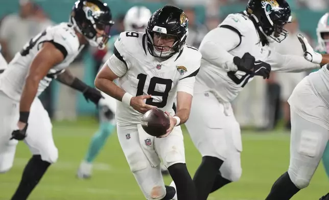 Jacksonville Jaguars quarterback Seth Henigan (19) looks to hand off the football during the second half of an NFL preseason football game against the Miami Dolphins, Saturday, Aug. 23, 2025, in Miami Gardens, Fla. (AP Photo/Lynne Sladky)