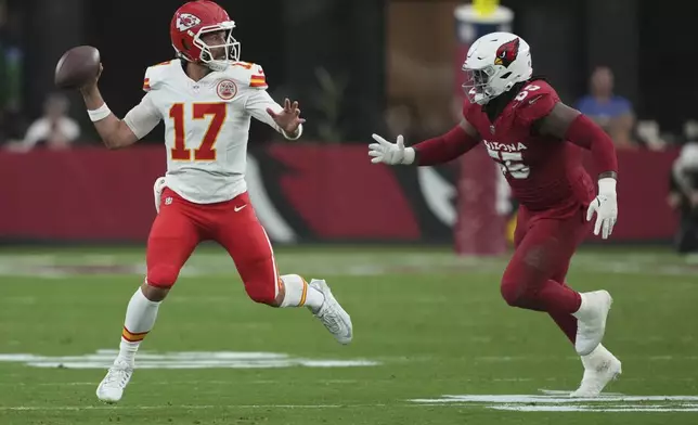 Kansas City Chiefs quarterback Gardner Minshew (17) looks to throw under pressure from Arizona Cardinals defensive tackle Dante Stills (55) during the first half of an NFL preseason football game, Saturday, Aug. 9, 2025, in Glendale. (AP Photo/Rick Scuteri)
