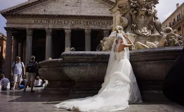 FILE - A bride poses for photos in front of Rome's Pantheon, June 28, 2013. (AP Photo/ Domenico Stinellis, File)