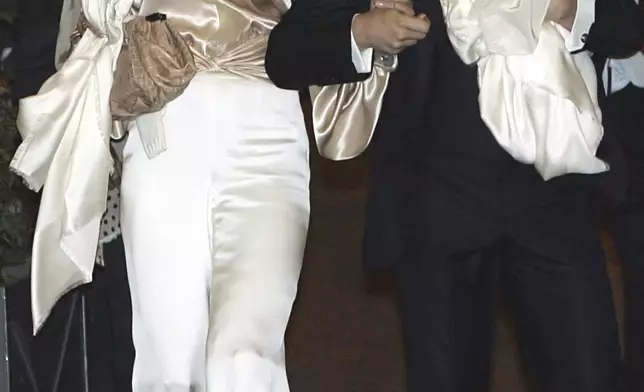 FILE - U.S. actor Tom Cruise, right, and U.S. actress Katie Holmes with their daughter Suri, who became engaged in June 2005, hold hands as they leave their hotel ahead of their wedding ceremony in Rome, Nov. 16, 2006. (AP Photo/Gregorio Borgia, File)