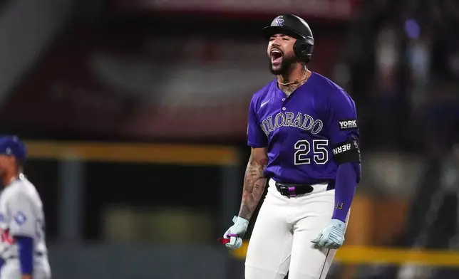 Colorado Rockies' Warming Bernabel celebrates after hitting a walk-off RBI single off Los Angeles Dodgers relief pitcher Justin Wrobleski in the ninth inning of a baseball game Monday, Aug. 18, 2025, in Denver. (AP Photo/David Zalubowski)