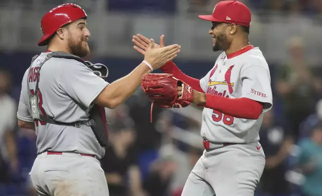 St. Louis Cardinals catcher Pedro Pages, left, shakes hands with relief pitcher Jorge Alcala, right, after defeating the Miami Marlins in a baseball game, Monday, Aug. 18, 2025, in Miami. (AP Photo/Lynne Sladky)