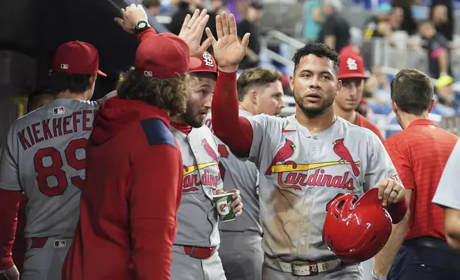 St. Louis Cardinals' Willson Contreras is congratulated in the dugout after scoring on a two run home run hit by Nolan Gorman during the ninth inning of a baseball game against the Miami Marlins, Monday, Aug. 18, 2025, in Miami. (AP Photo/Lynne Sladky)