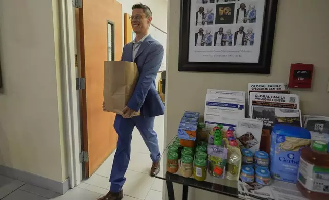 Felipe Sousa Lazaballet, executive director of the Hope Community Center moves items from the food pantry Thursday, Aug. 14, 2025, in Apopka, Fla. (AP Photo/John Raoux)