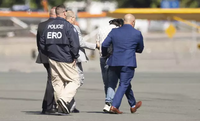 Harjinder Singh is escorted to an airplane by Florida Lt. Gov. Jay Collins and law enforcement on Thursday, Aug. 21, 2025, in Stockton, Calif. (AP Photo/Benjamin Fanjoy)