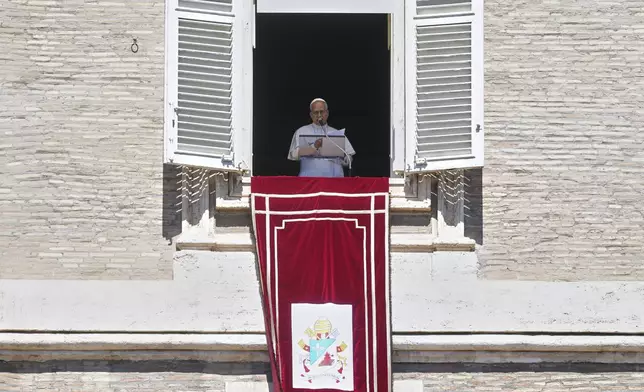 Pope Leo XIV delivers his blessing as he recites the Angelus noon prayer from the window of his studio overlooking St.Peter's Square, at the Vatican, Sunday, Aug. 31, 2025. (AP Photo/Andrew Medichini)