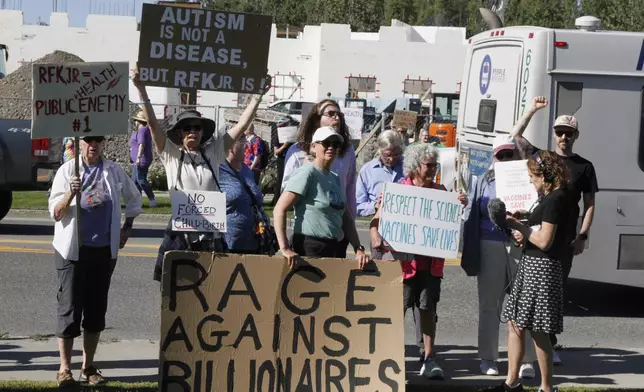 Protesters hold signs and chant outside the Alaska Native Tribal Health Consortium where U.S. Health Secretary Robert F. Kennedy Jr. met with Alaska Native leaders, in Anchorage, Alaska, Tuesday, Aug. 5, 2025, shortly after the Department of Health and Human Services announced its plans to cancel contracts and pull funding for some vaccines being developed to fight respiratory viruses like COVID-19 and the flu. (AP Photo/Mark Thiessen)