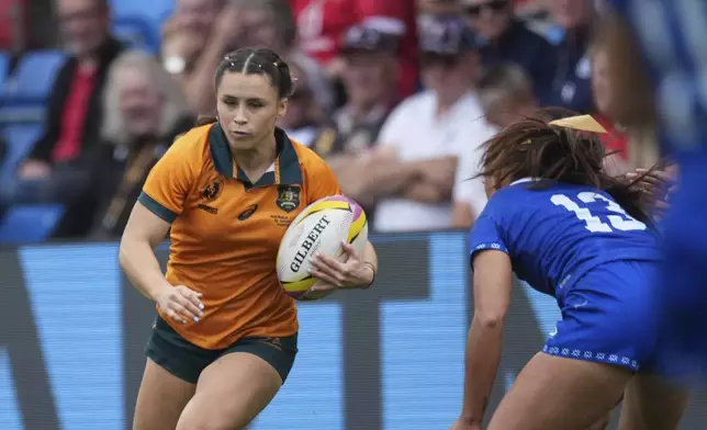 Desiree Miller of Australia, left, runs past Keilamarita Pouri-Lane of Samoa during the group A match at the 2025 Women's Rugby World Cup between Australia and Samoa in Manchester, England, Saturday, Aug. 23, 2025. (AP Photo/Dave Shopland)