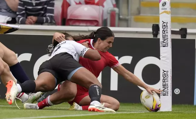 Canada's Julia Schell scores a try during the Women's Rugby World Cup 2025 Pool B match between Canada and Fiji at the York Community Stadium in York, England, Saturday, Aug. 23, 2025. (Danny Lawson/PA via AP)