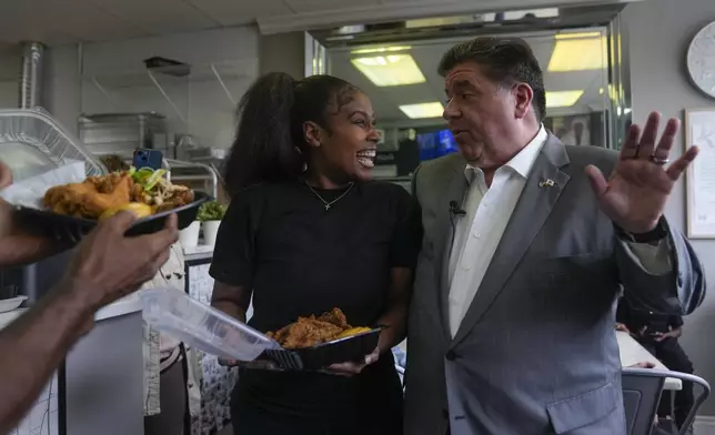 Illinois Gov. J.B. Pritzker, right, visits with Chef Kristen Ashley at her restaurant, Cleo's Southern Cuisine, Wednesday, Aug. 27, 2025, in the Bronzeville neighborhood of Chicago. (AP Photo/Erin Hooley)