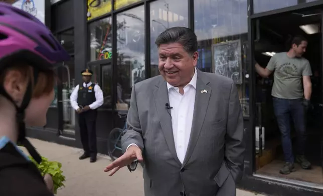Illinois Gov. J.B. Pritzker talks to people outside of Small Shop Cycles &amp; Service, Wednesday, Aug. 27, 2025, in the Bronzeville neighborhood of Chicago. (AP Photo/Erin Hooley)
