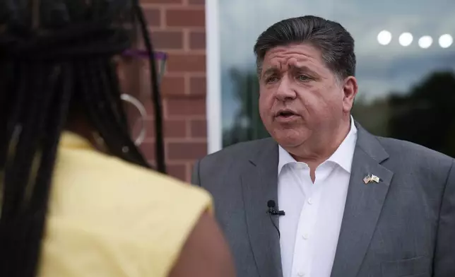 Illinois Gov. J.B. Pritzker talks to a woman outside of a store Wednesday, Aug. 27, 2025, in the Bronzeville neighborhood of Chicago. (AP Photo/Erin Hooley)