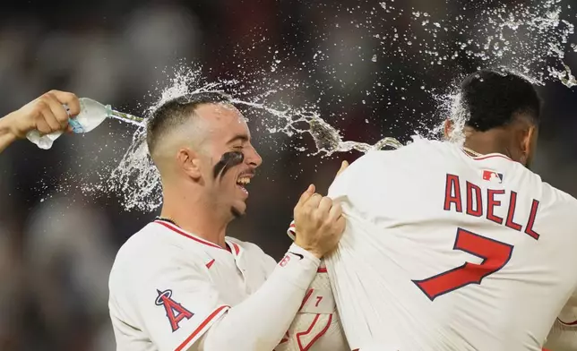 Los Angeles Angels' Jo Adell, right, celebrates with Zach Neto after hitting a wal-off single during the 10th inning of a baseball game against the Los Angeles Dodgers, Tuesday, Aug. 12, 2025, in Anaheim, Calif. (AP Photo/Mark J. Terrill)